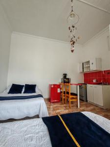 Cet appartement comprend une chambre avec deux lits et une cuisine avec des placards rouges. dans l'établissement Hostal Vicmar, à Viña del Mar