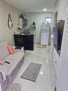 a living room with a couch and a refrigerator at Hospedagem do Elias in Cuiabá