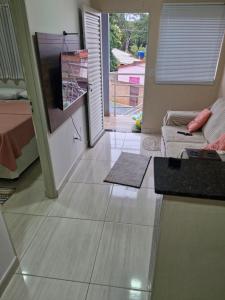 a living room with a sliding glass door and a television at Hospedagem do Elias in Cuiabá +4 photos