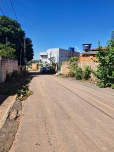 an empty road with a car parked on the side at Hospedagem do Elias in Cuiabá