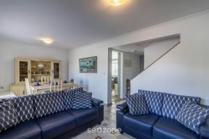 - un salon avec deux canapés bleus et un escalier dans l'établissement Casa em Cabo Frio a 200m da praia ADP001, à Peró