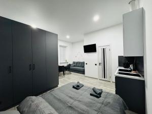 Un dormitorio con una cama grande y una cocina. en Studio Apartment центр міста Чернівці, en Chernivtsi