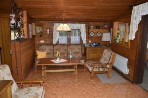 ein Wohnzimmer mit Tisch und Stühlen und eine Küche in der Unterkunft Almhaus auf 1600m Seehöhe mit Sauna und Kaminöfen in Klippitztorl