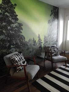 a living room with two chairs and a green wall at Scandinavian Home in Rovaniemi