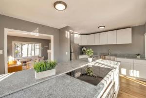une cuisine avec des armoires blanches et un grand îlot avec des plantes dans l'établissement Urban Haven in Oakland with Easy Transit, à Oakland 3 autres photos