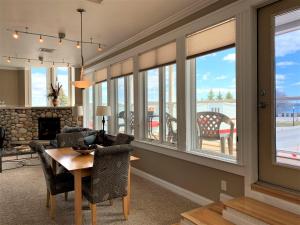 un salon avec une table, des chaises et des fenêtres dans l'établissement Pier Harbor #2, à Saint-Ignace
