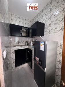 a kitchen with a refrigerator and a stone wall at DHSimmo Cozy home in Rufisque