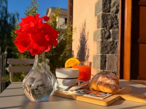 une table avec un vase contenant une fleur rouge et du pain dans l'établissement Agriturismo Il Sole e Il sale, à Acireale
