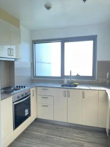 eine Küche mit weißen Schränken und einem großen Fenster in der Unterkunft 95 Sqm Flawless Seaview Luxurious Modern 2 Bedrooms Facing Manila Bay Sunset, Airports, Okada, Solaire, MOA with free parking in Manila