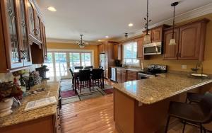 a kitchen with wooden cabinets and a kitchen island with chairs at CAL56Left in Alton