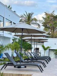 une rangée de chaises avec des parasols devant un bâtiment dans l'établissement Newport Hotel, à Atimpoko
