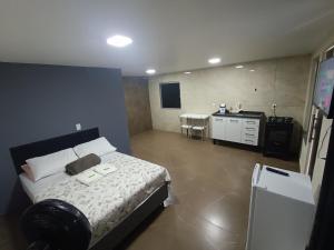 a bedroom with a bed and a kitchen with a table at Chalé Montanhez com ar e piscina in Caparaó Velho