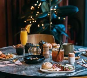 a table with plates of food and a glass of orange juice at La Bulle de Velours in Bouguenais +23 photos