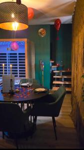 a dining room with a table and chairs and candles at La Bulle de Velours in Bouguenais