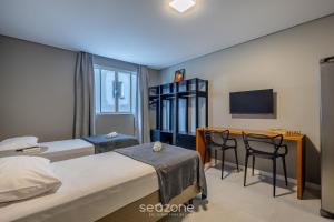 En eller flere senge i et værelse på Estúdios na Barra em Balneário Camboriú - DPR