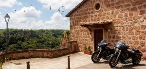een motorfiets geparkeerd voor een bakstenen gebouw bij Antica Rupe Casa Vacanze in Castel SantʼElia