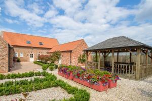 a garden with a gazebo and some flowers at Meals Farm - Courtyard Room in North Somercotes