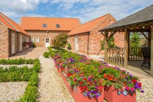 rząd skrzynek kwiatowych w ogrodzie w obiekcie Meals Farm - Courtyard Room w mieście North Somercotes