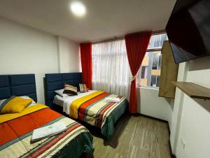 deux lits dans une chambre avec une fenêtre dans l'établissement Hotel Inkanta, à Nariño