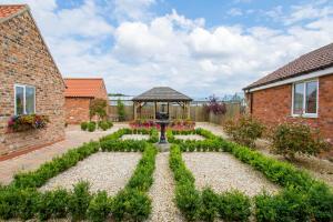 a garden with a fountain and a gazebo at Meals Farm - Courtyard Room in North Somercotes