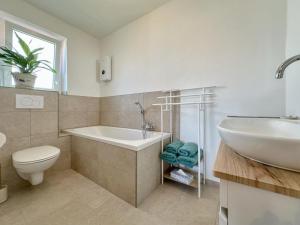 une salle de bain avec une baignoire, un lavabo et des toilettes dans l'établissement Hochfels, à Stadlern 27 autres photos