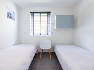a room with two beds and a chair in it at Waterfront in Uitgeest