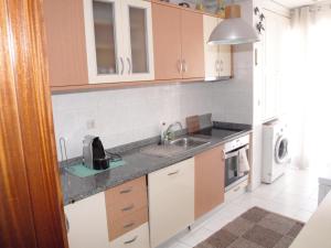 a kitchen with a sink and a microwave at EPS53 T1,luminoso apartamento, 800m praia Apulia in Apúlia