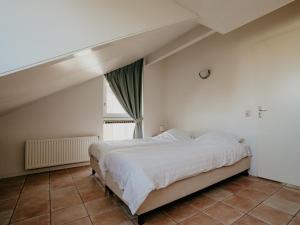 a bedroom with a large bed and a window at Busch en Dam in Uitgeest