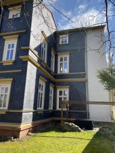 a blue and white house with a yard at Villa Am Kurpark in Friedrichroda