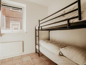 een slaapkamer met een stapelbed en een raam bij Westergeest in Uitgeest