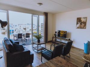 een woonkamer met een bank, stoelen en een tafel bij Westergeest in Uitgeest