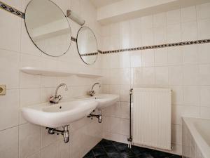 een witte badkamer met 2 wastafels en een spiegel bij Westergeest in Uitgeest