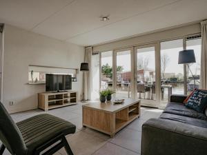a living room with a couch and a tv at Dorregeest in Uitgeest