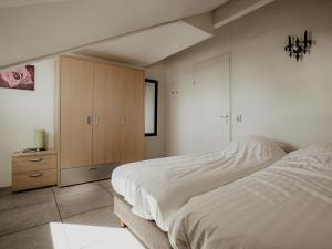 a bedroom with a bed and a wooden cabinet at Dorregeest in Uitgeest