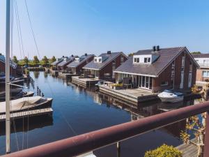 a group of houses on a river with boats at Dorregeest in Uitgeest