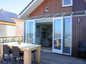 a patio with a table and chairs and a house at Oostergeest in Uitgeest