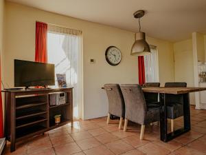 a living room with a dining room table and a clock at Waterbase in Uitgeest