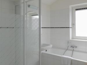 a white bathroom with a shower and a sink at Dorregeest in Uitgeest +15 photos