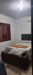 a bedroom with a bed with a wooden board on it at Casa da Carmem in São Gabriel