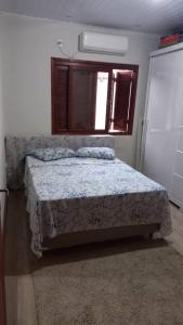 a bedroom with a bed in a room with a window at Casa da Carmem in São Gabriel