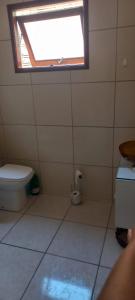 a bathroom with a toilet and a window at Casa da Carmem in São Gabriel