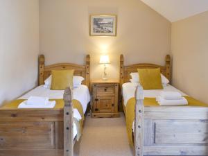 a bedroom with two beds and a night stand with twounks at Ferguson in Warenford