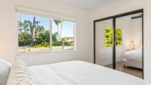 圣克莱门特Steps to Beach Hot Tub Private Patio 259 Trailhead Trestles 3 by AvantStay的一间带床和窗户的白色卧室