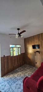 a living room with a couch and a ceiling fan at casa da Cilene in Ilha Grande