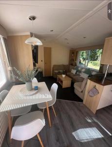 un salon avec une table et des chaises blanches dans l'établissement Lovely 8 Berth Caravan With Side Decking At Haven Cleethorpes Beach Ref 48033F, à Humberston