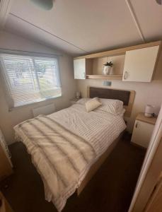 - une chambre avec un grand lit et une couette blanche dans l'établissement Lovely 8 Berth Caravan With Side Decking At Haven Cleethorpes Beach Ref 48033F, à Humberston