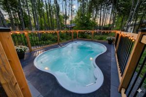 Pont-RougeLakay-SPA Piscine Billards 25 min de Québec的庭院设有热水浴池和围栏