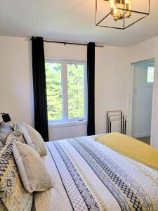 Pont-RougeLakay-SPA Piscine Billards 25 min de Québec的一间卧室，里面有一张床和一扇窗户。 更多32张照片