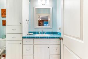 ein Badezimmer mit Waschbecken und Spiegel in der Unterkunft Tenth Street Retreat in Tybee Island + 82 Fotos