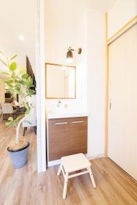 a bathroom with a sink and a stool at KOTOVilla JR琴平駅近く丸々貸切一棟室内アスレチック in Kotohira